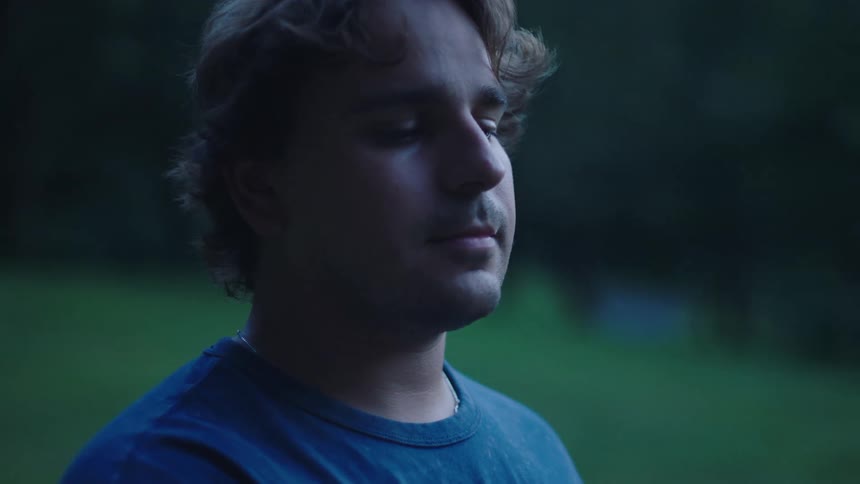 A man stands outside and looks at a distance