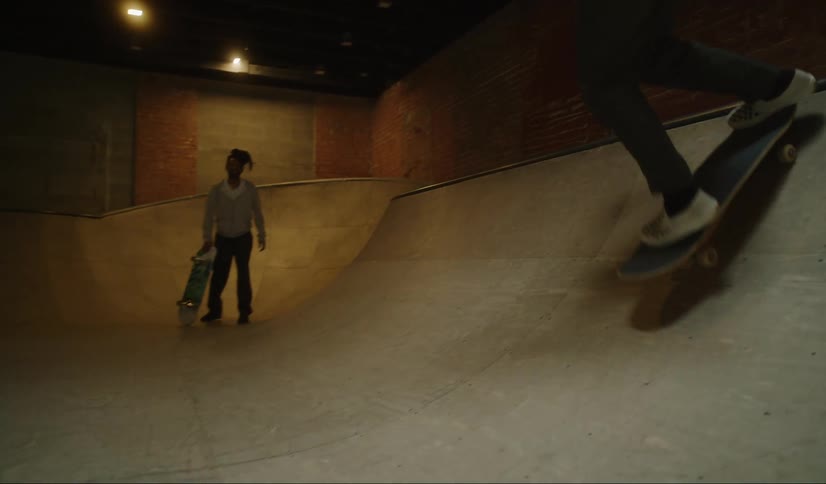 A girl rides the ramp on a skateboard