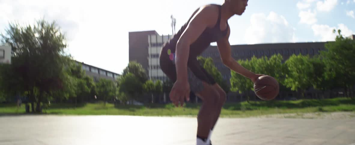 Man with black shirt and shorts plays basketball on court