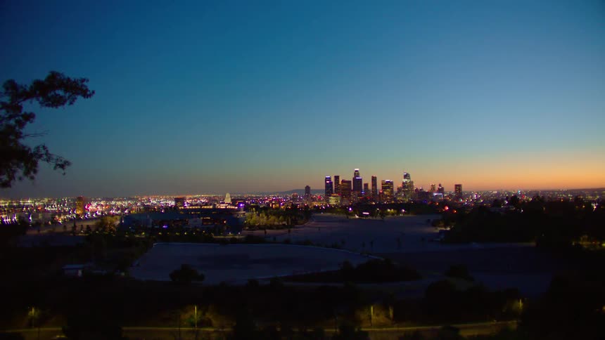 City skyline with illuminated high rise buildings at dusk