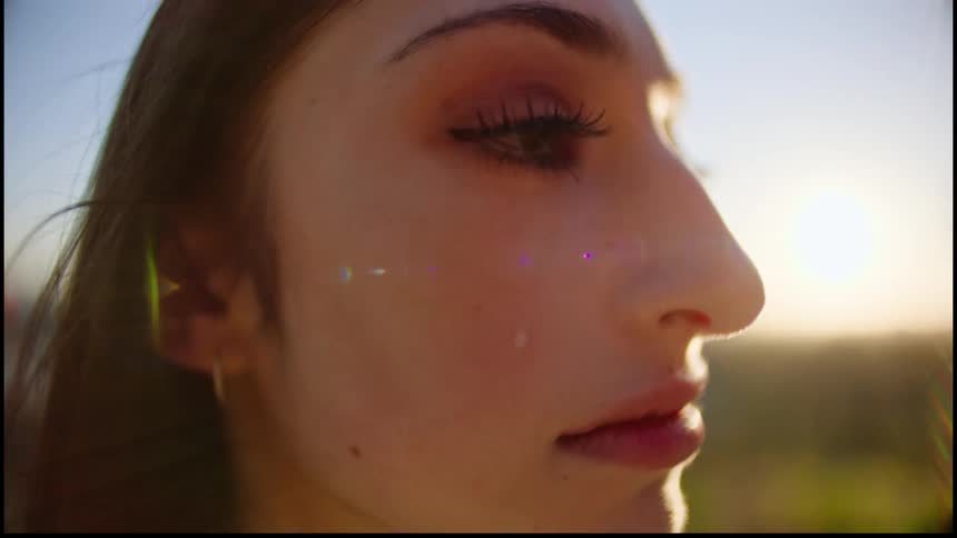 A tear runs down a womans cheek as she stands outside