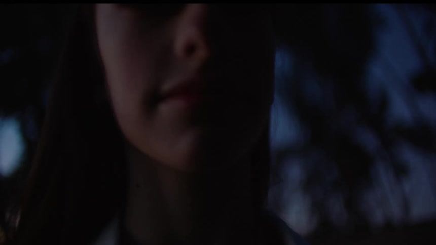 Woman stands outdoors in shadow starring