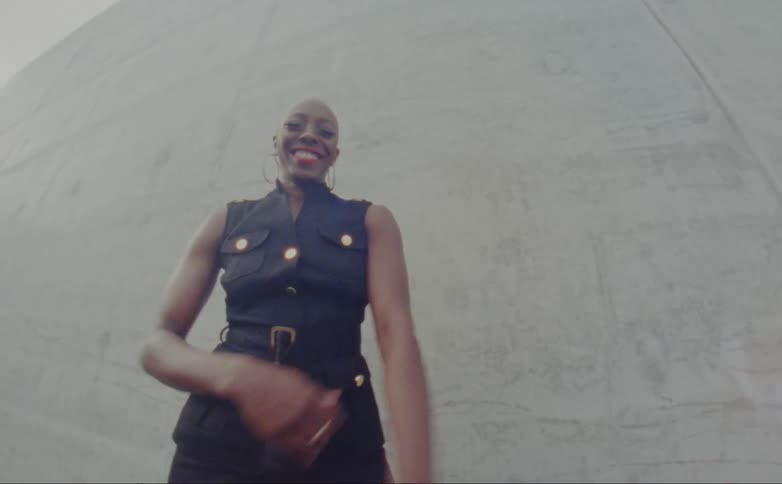 A woman is posing outside by the wall