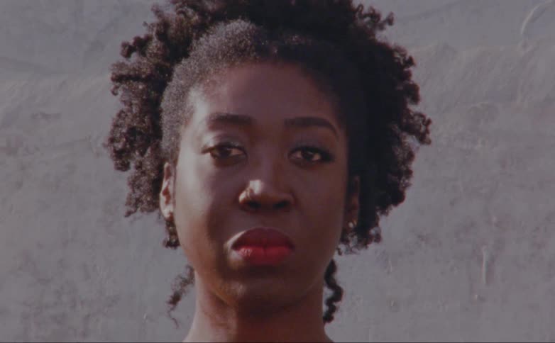 Black woman blinks her eyes as she stares