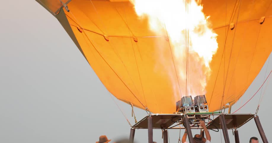 A group of people are waiting as a hot air balloon fills