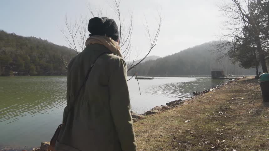 A person walking next to a lake