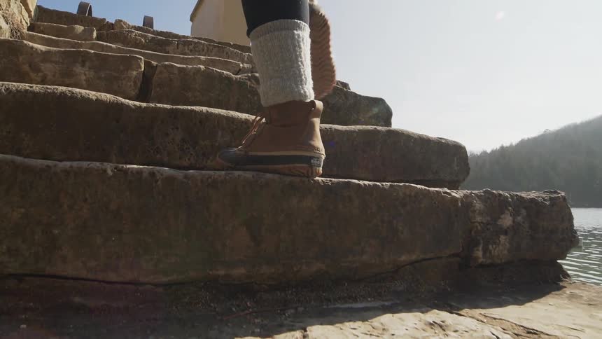 Person walking to some steps by the water and climbing them
