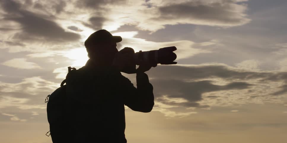 Man holds a camera up to take a picture