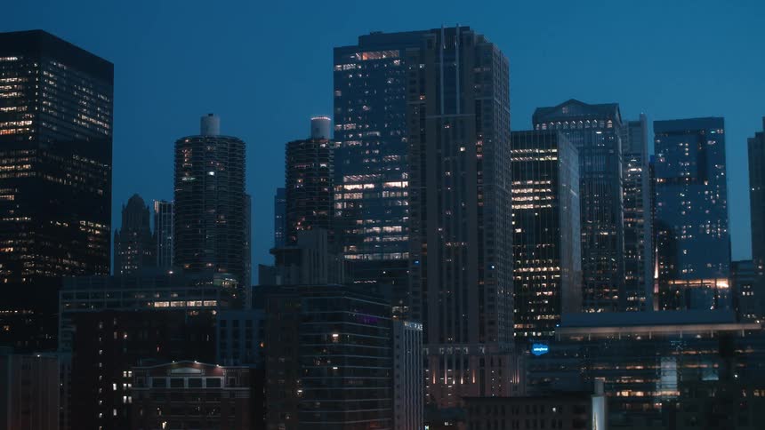 Illuminated skyscrapers with office buildings in the city at night