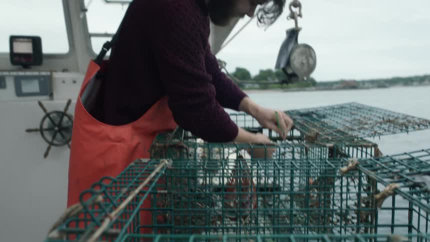 A fisherman is setting the trap on a cage