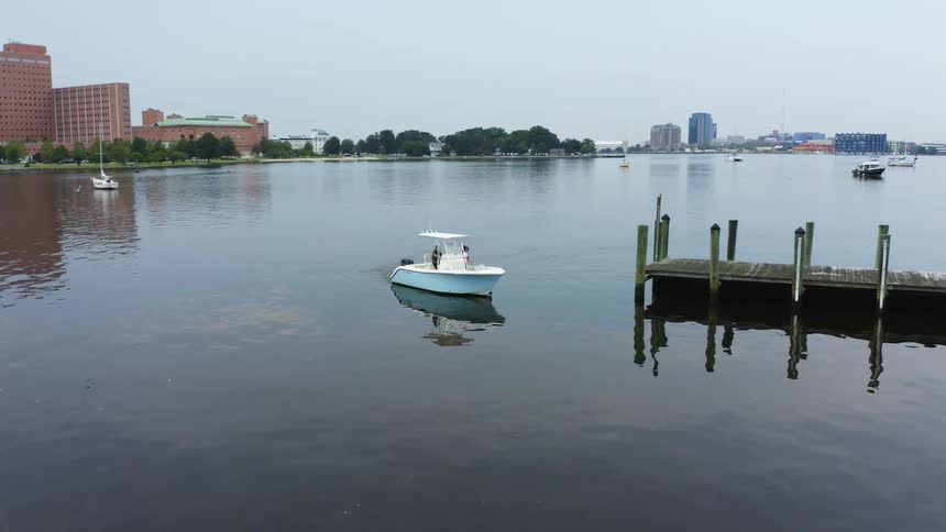 Two people ride up to the pier on a boat