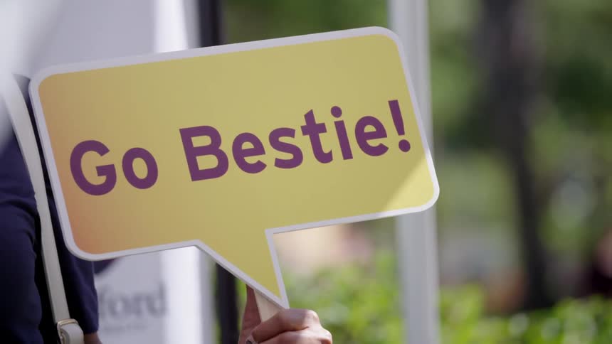 A person holds their sign outside