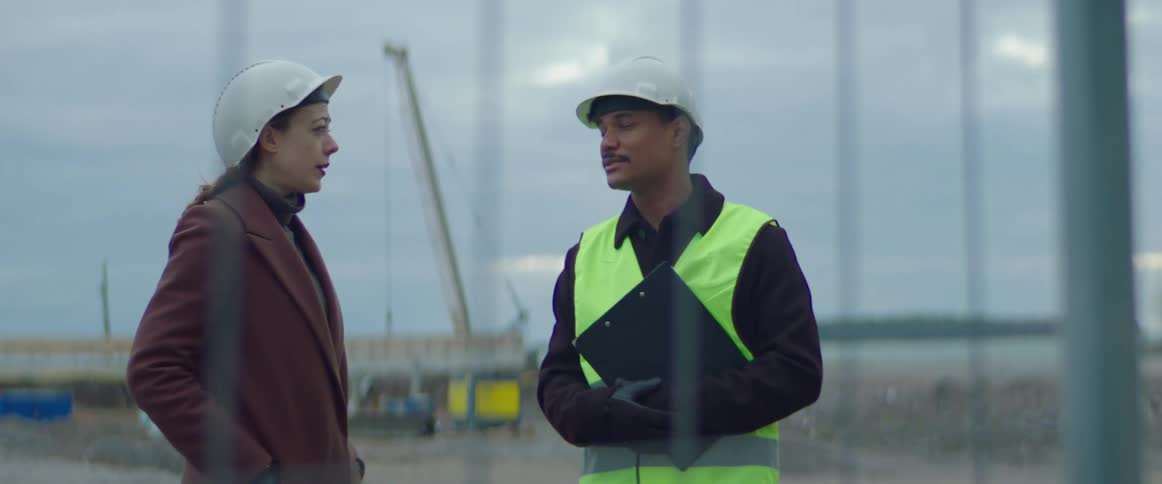 A construction worker talking to a woman