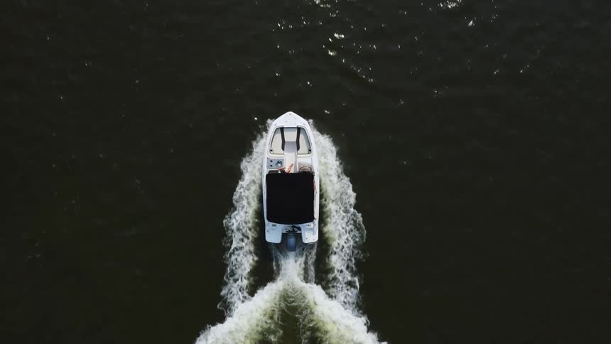 Aerial view of a small boat traveling across the water