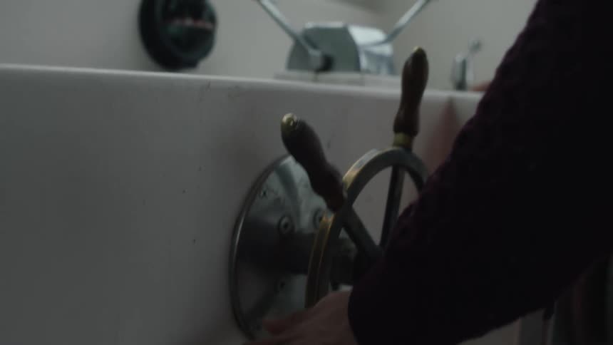 Close up of a man steering the helm on a boat
