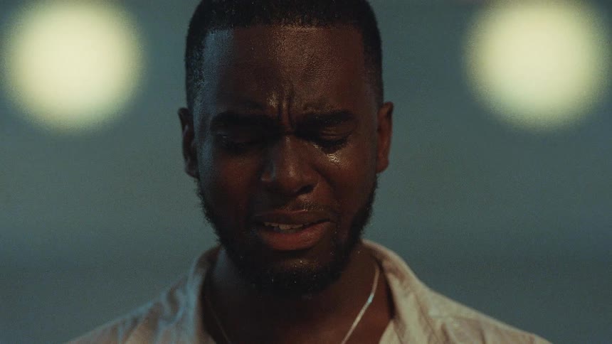 Man with beard necklace and white shirt weeps uncontrollably
