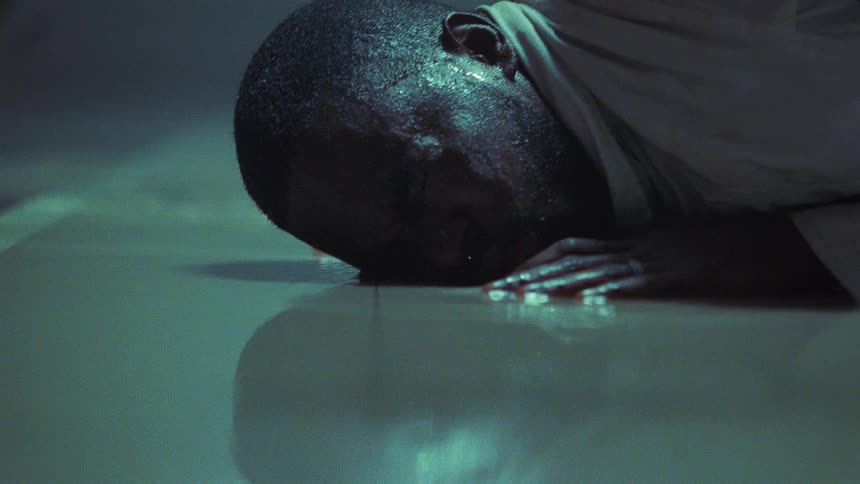 A man struggles to breathe and get up as he lies face down in shallow water