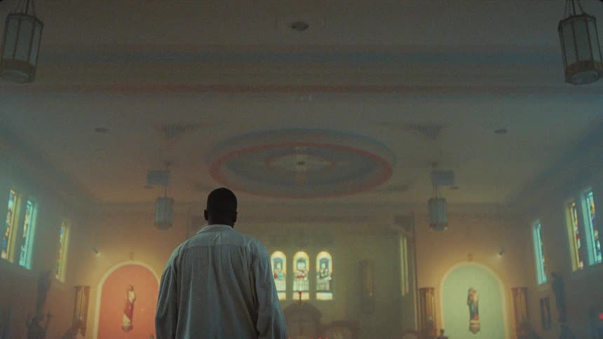 Black man limping down the aisle of an empty church towards the church altar