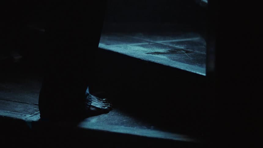 Closeup of a mans bare feet walking up steps leaving wet footprints