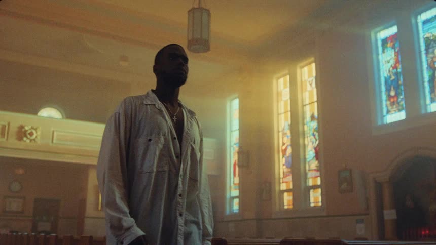 A man slowly walks down a church aisle and looks around