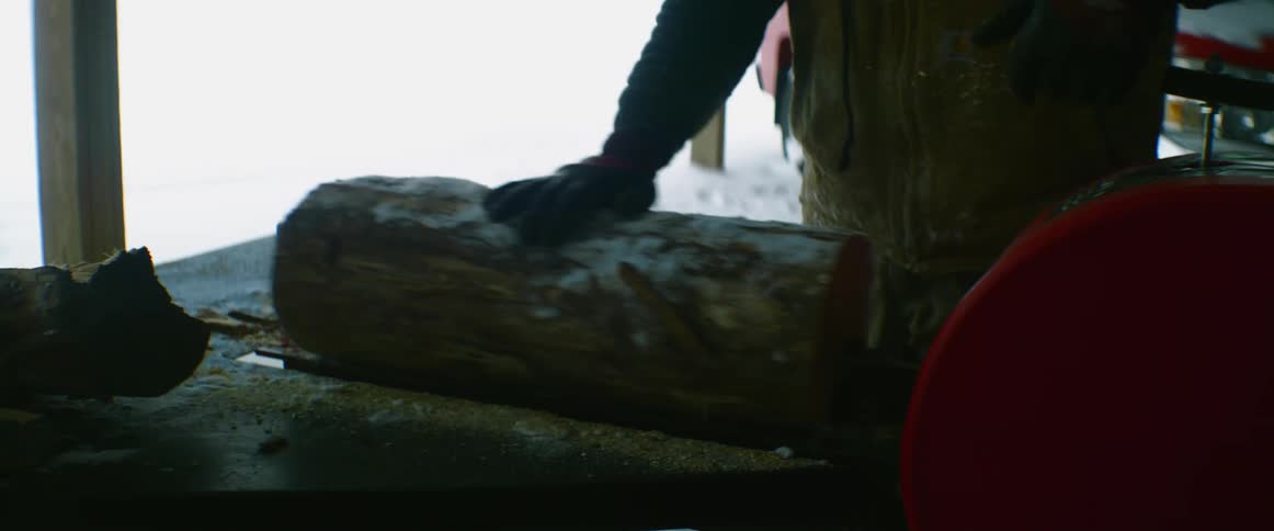 A person splitting logs outdoors