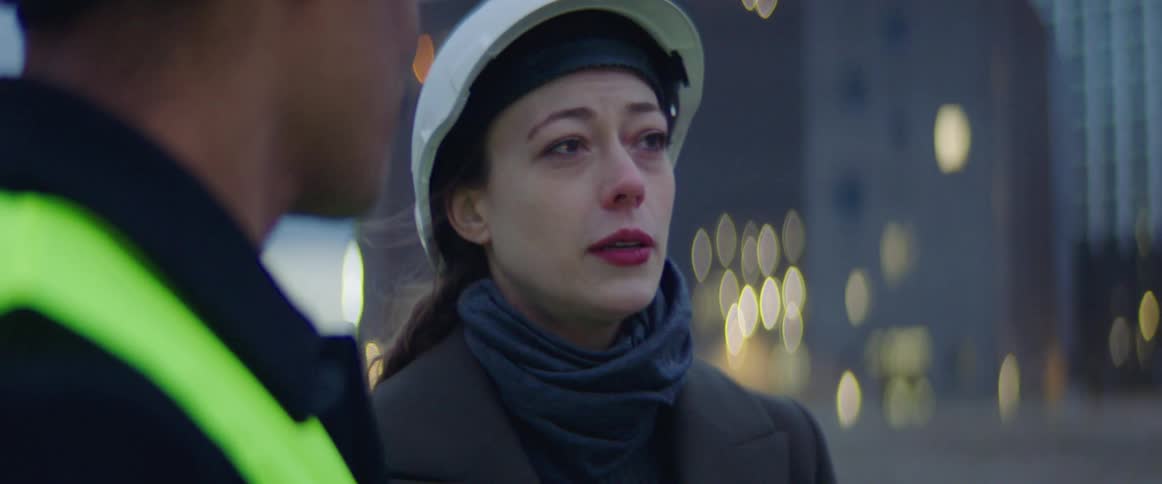 Woman wears hardhat while having a discussion with a male worker in a safety vest