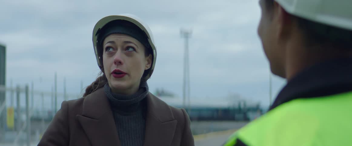 A woman talks with a construction worker
