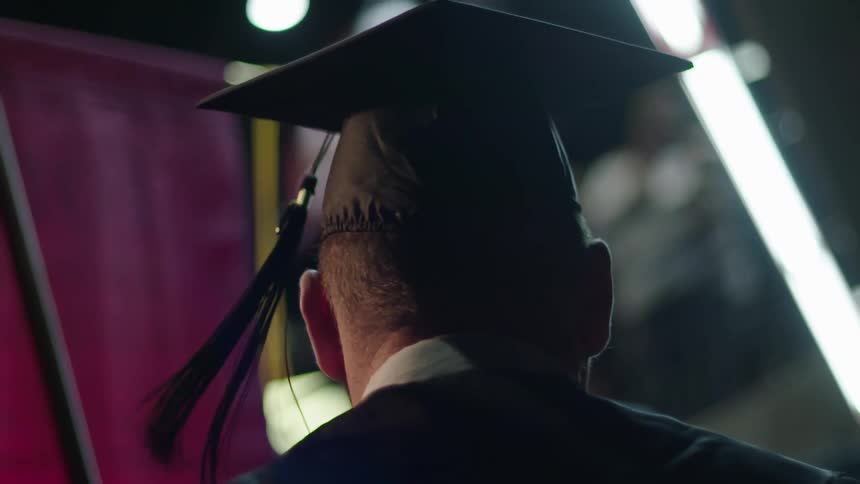 A man is wearing a cap and gown