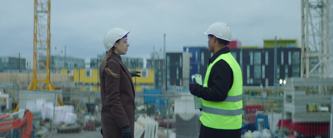 Two construction workers talk together at a job site