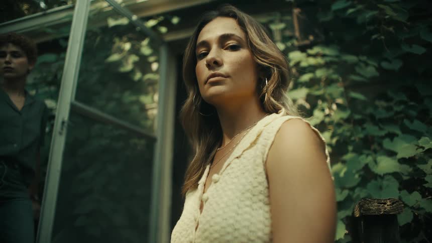A woman is posing outside the house