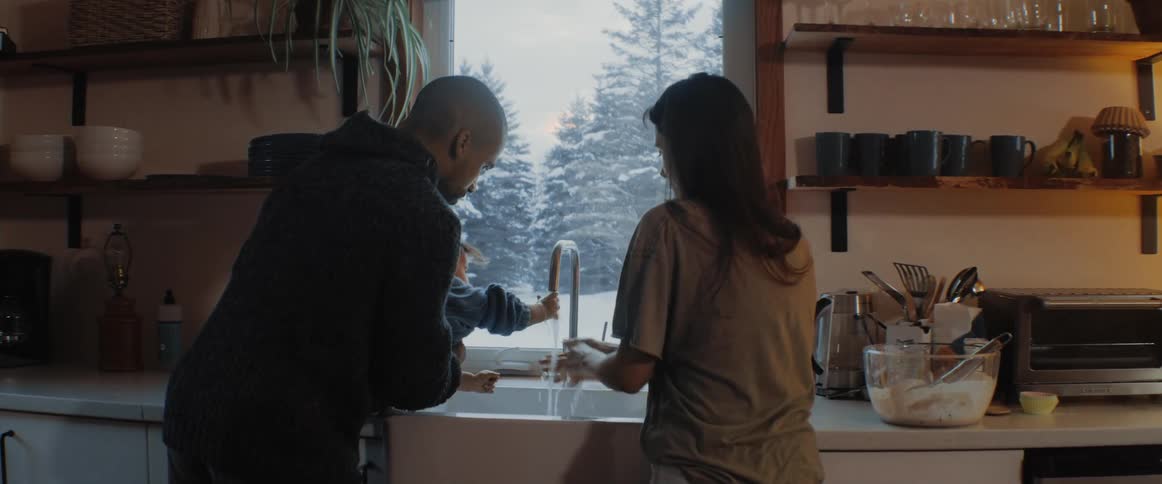 Parents clean their sons hands in the sink