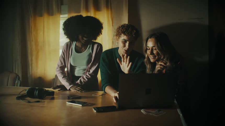 Women talk and look at a laptop