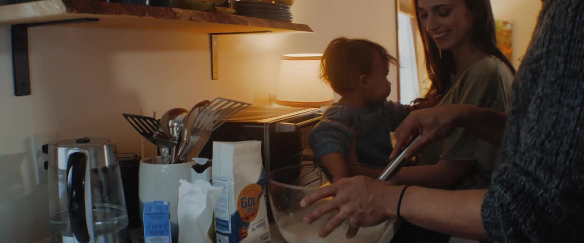 A family mix together a bowl of batter in their kitchen