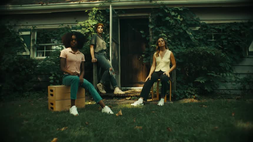 Three women pose in the yard