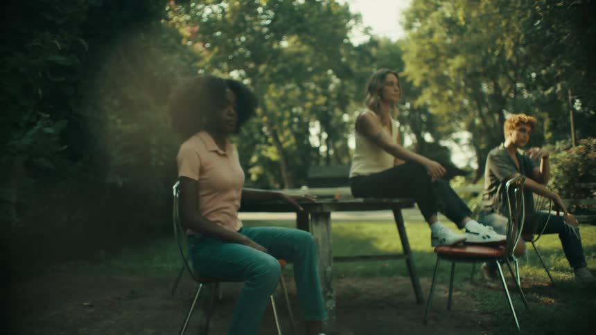A group of young women pose outside near a photo shoot setup