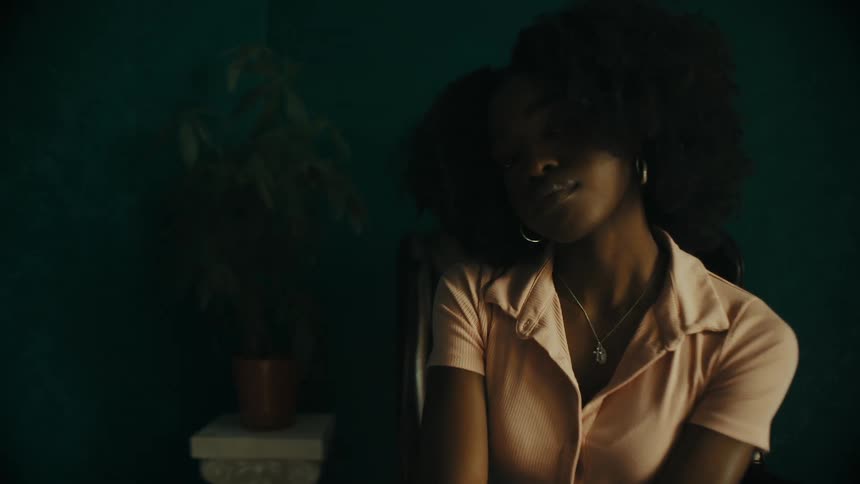 Black woman sitting at an armchair in an empty room