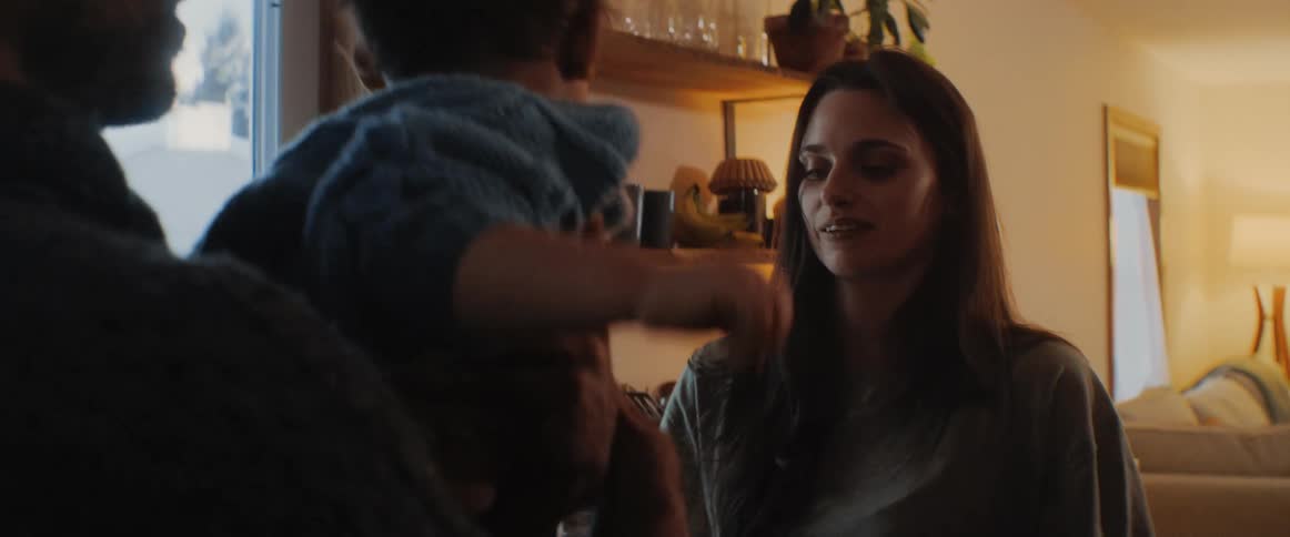 Mother smiles and cleans childs hands as father holds the child