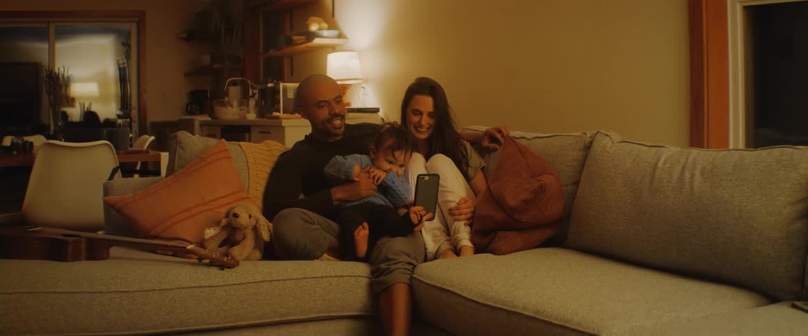 A family sit on the couch together