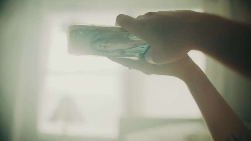 A view of a woman laying on a bed with a smartphone