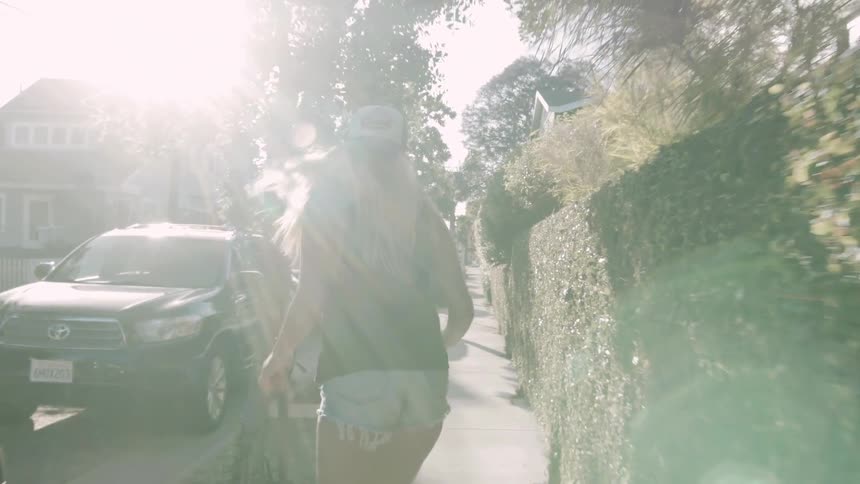 Woman skateboarding on a neighborhood sidewalk