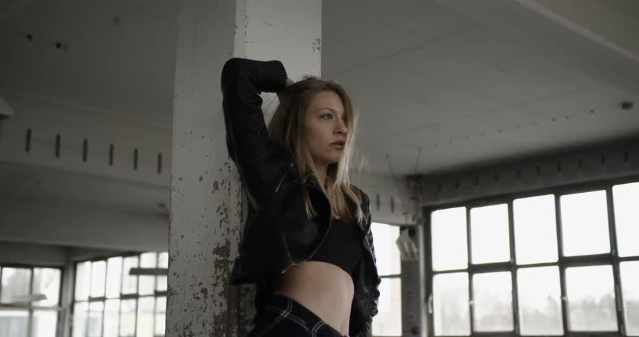 A young woman practicing dance moves in an abandoned building