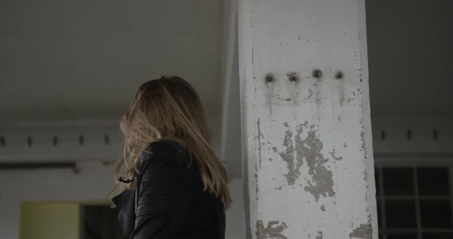 A woman dances by herself in a warehouse