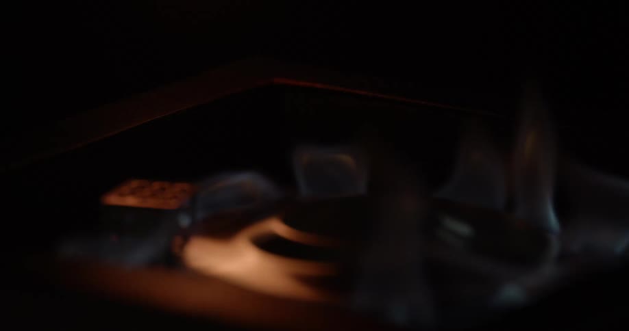 A match ignites the flames on a gas stove burner
