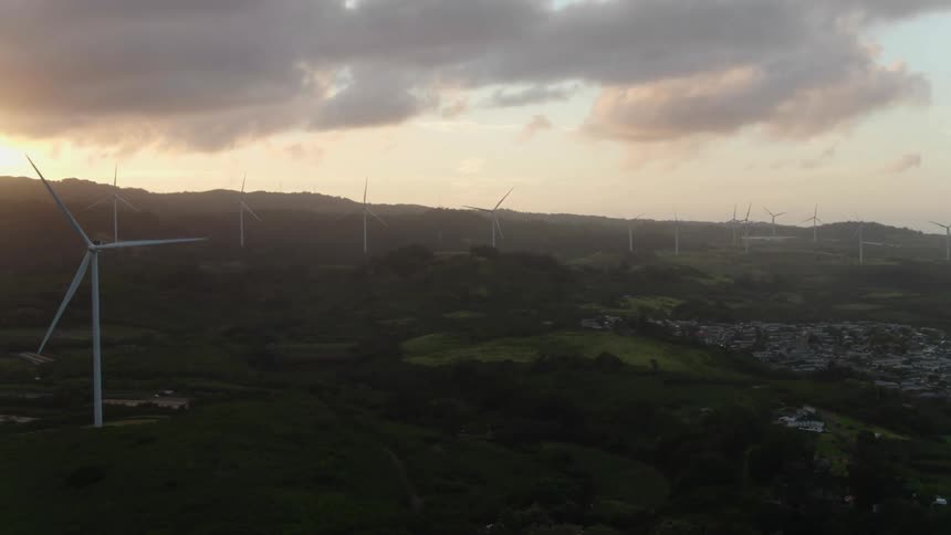 Aerial view of wind turbines on wind farm at sunset