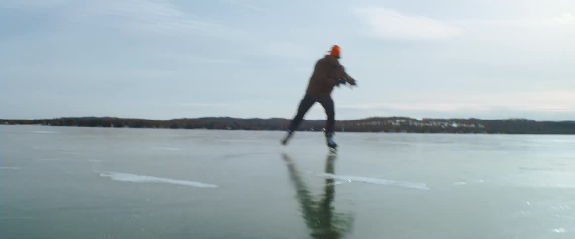 A man ice skates down a frozen lake