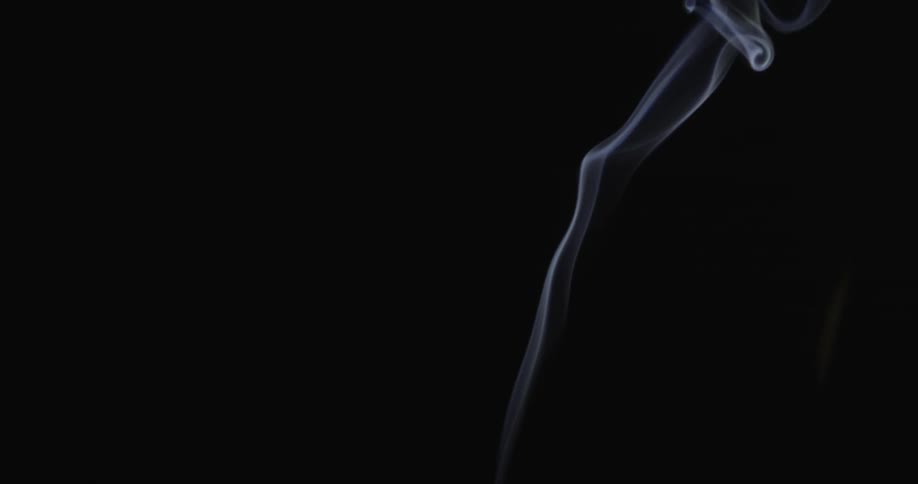 Smoke rises up on dark background