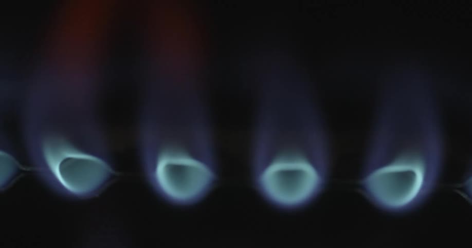 Close up view of blue flames from a gas stove burner