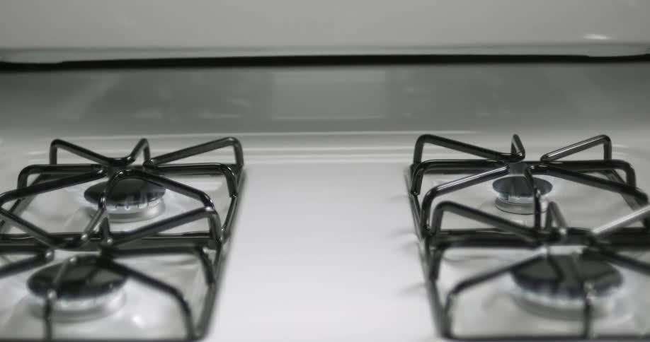 Flames emerge from burners on a gas stove