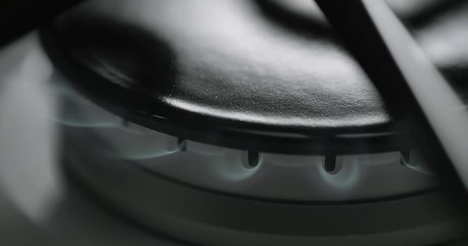 Close up view of blue flames from a gas stove burner