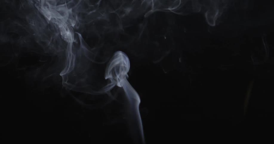 White smoke rising against a black background